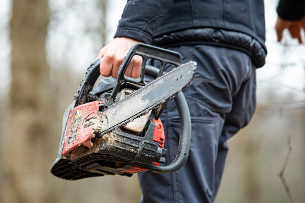 Individual carrying a chainsaw