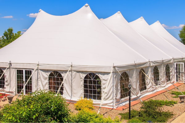 White party tent set up outdoors on a clear day