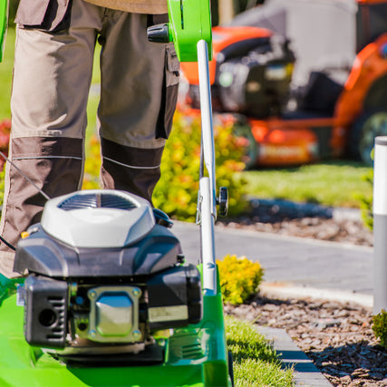 Lawn & Garden RentalsLandscaper with a push mower and a riding mower in the background